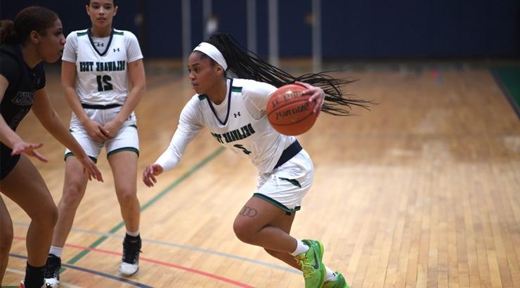 Delaware Tech women's basketball player Daqira Lancaster-Navarro charging past one of the opposition's defenders